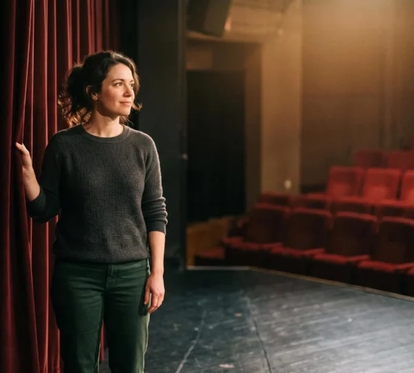 Adulte d'une trentaine d'années se tenant dans les coulisses d'un théâtre, hésitant avant d'entrer sur scène pour vaincre sa timidité